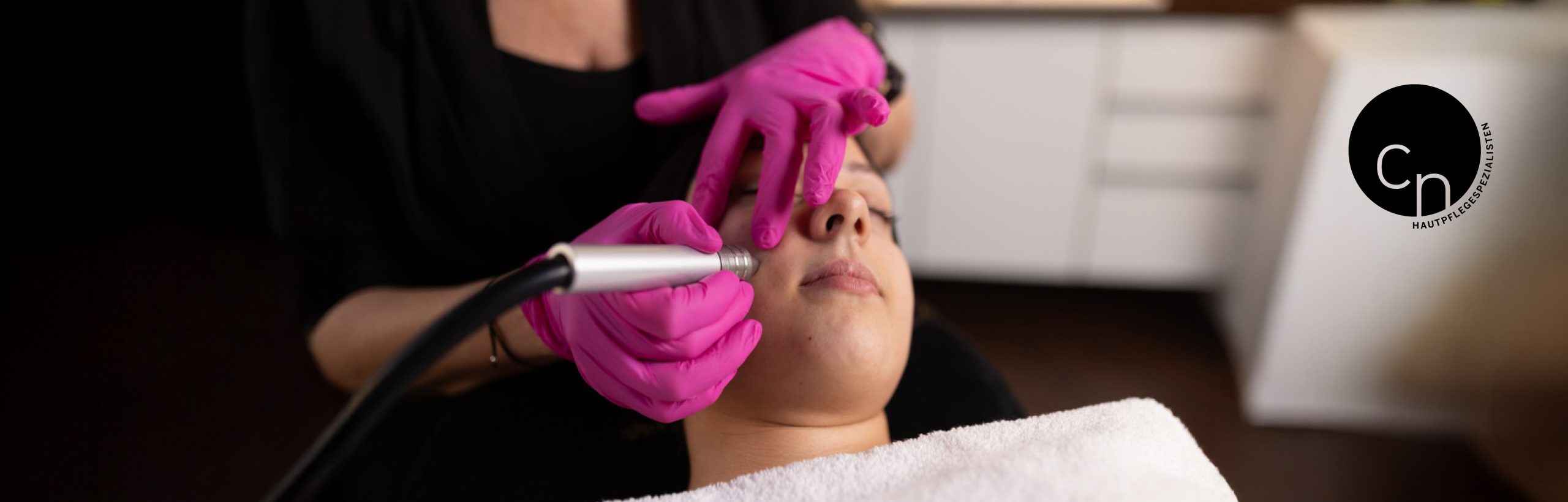 Microdermabrasion Behandlung: Handstück reinigt die Gesichtshaut einer Kundin